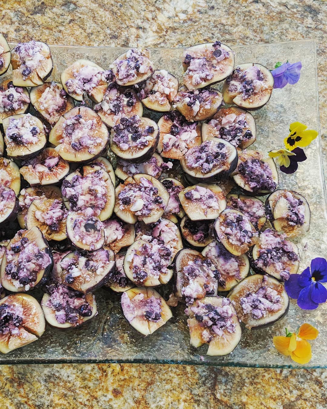 Blueberry and goat cheese stuffed figs topped with edible flowers
