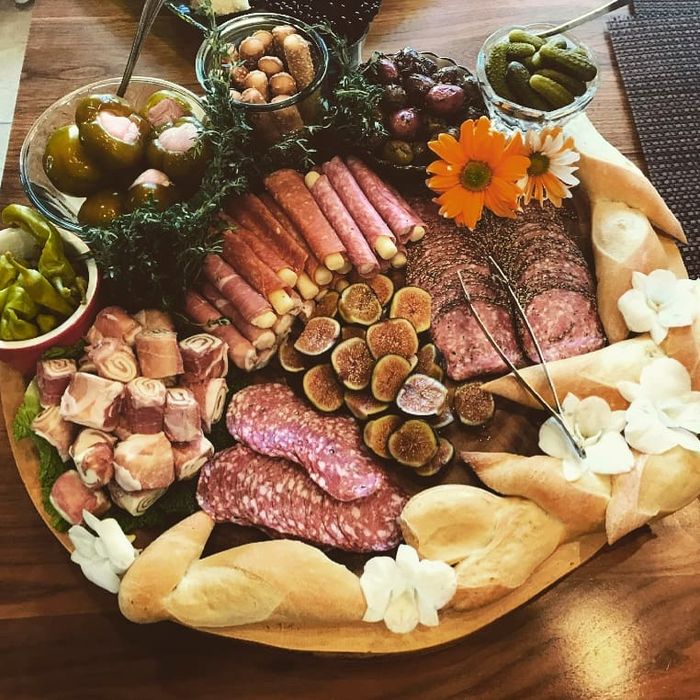 A large charcuterie board styled with sunflowers