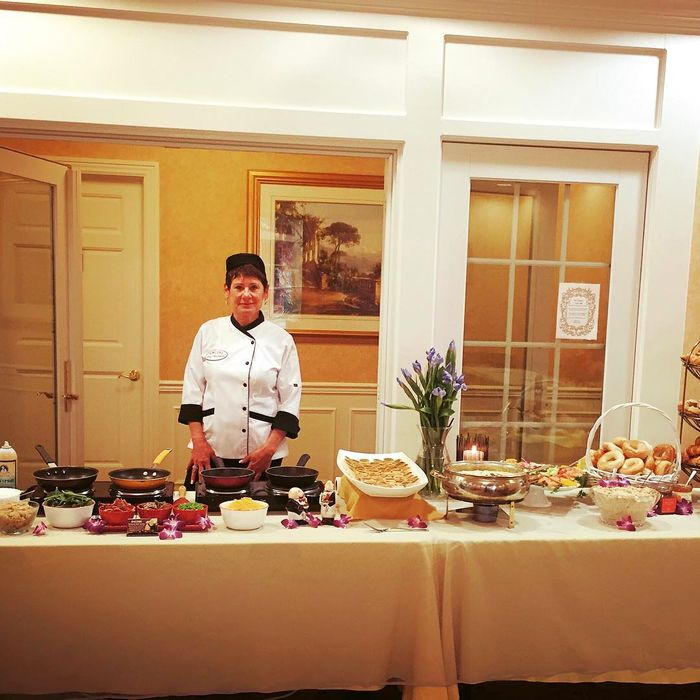 Chef Antoinette standing beside a catered buffet at a venue