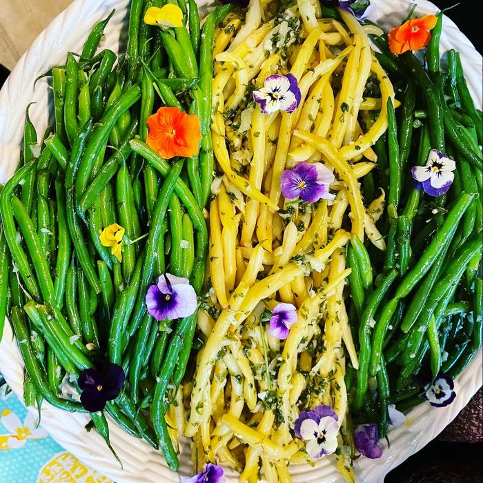Green beans and asparagus arranged with edible flowers